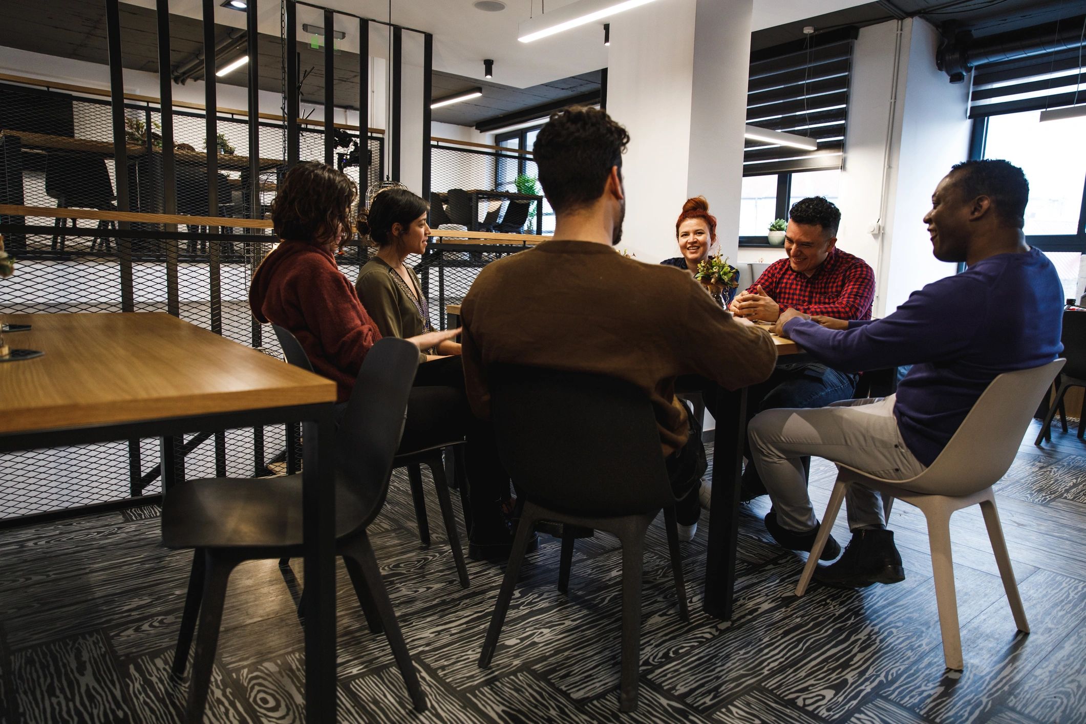 Coworkers talking together at a table in a lounge area