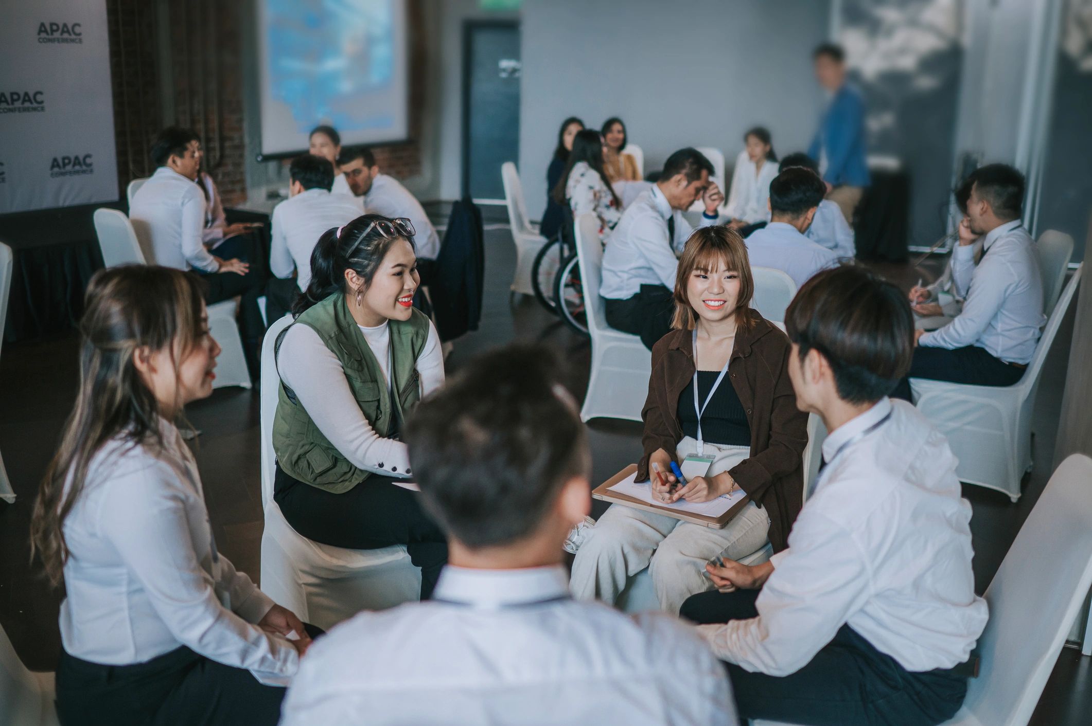 Team building, Asian workshop participants in small group discussion, brainstorming during business workshop class